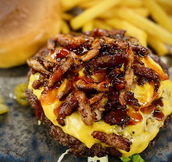 Smashburgare med cheddar, krispig bacon och BBQ-lök, rakt från grillplattan